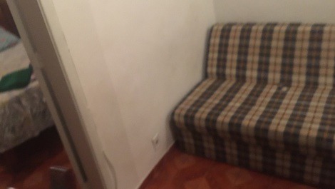Sala: geladeira duplex, mesa com 3 cadeiras, tv no suporte, sofá-cama e  1 ventilador de teto 