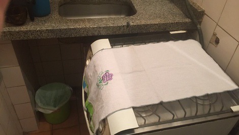 Cozinha: microondas no suporte, pia com  torneira filtro,  utensílios de cozinha( panelas, pratos, talheres) e fogão com 4 bocas 