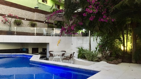 Piscina ducha com iluminação ao fundo churrasqueira 