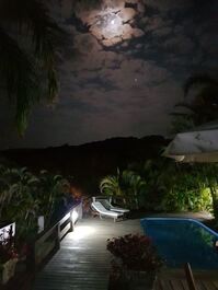 Deck com piscina ao anoitecer.
