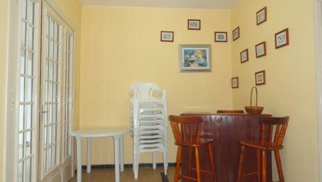 Agradável mini bar com banquetas. mesas e cadeiras brancas marfinite  para usar na área externa.