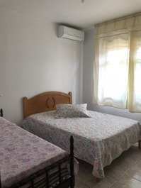 quarto com cama de casal, solteiro e ar.