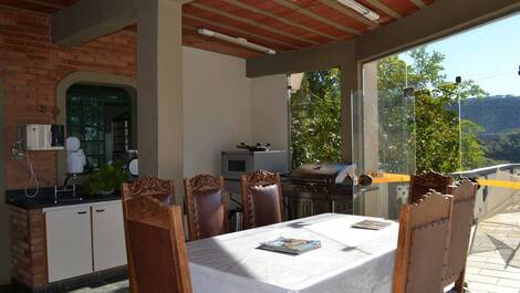 Cozinha externa com vista para piscina