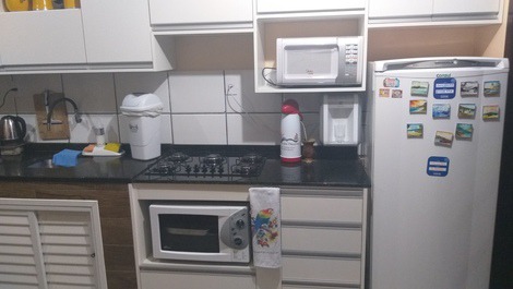 Cozinha compartilhada com fogão, geladeira, forno elétrico e micro-ondas