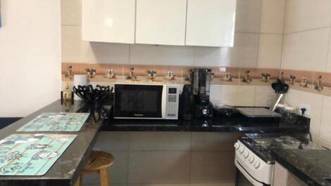 Alguns itens da cozinha: microondas, liquidificador, sanduicheira e talheres. cozinha é toda mobiliada. 