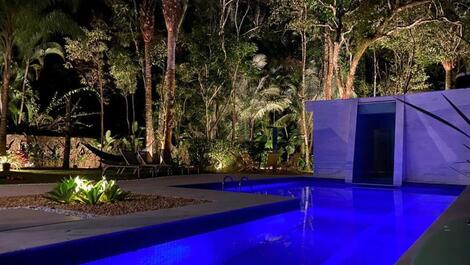 Visao noturna piscina e área verde