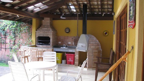 Espaco gourmet integrado com churrasqueira e forno de pizza.