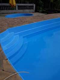 Piscina adulto e infantil ao fundo