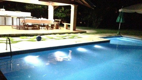 Piscina à noite e churrasqueira