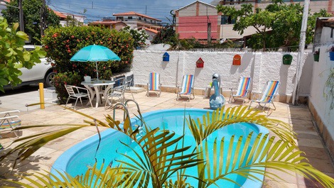 Visão da piscina com 10 cadeiras de praia, conj. de mesa e cadeiras, sombreiro