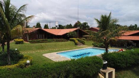 PISCINA COM CASA AO FUNDO