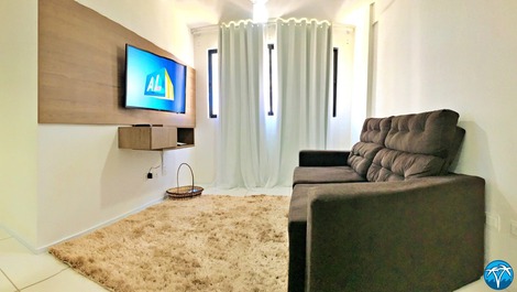 Sala de estar espaçosa com sofá retrátil e smart tv.