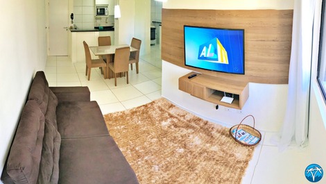 Sala de estar espaçosa com sofá retrátil e smart tv.