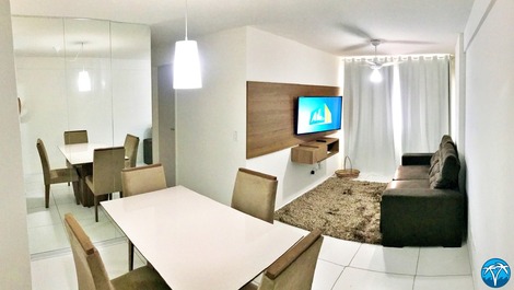 Sala de estar espaçosa com sofá retrátil e smart tv.