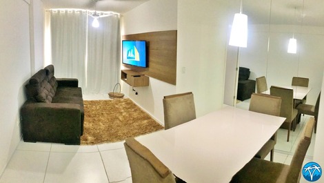 Sala de estar espaçosa com sofá retrátil e smart tv.