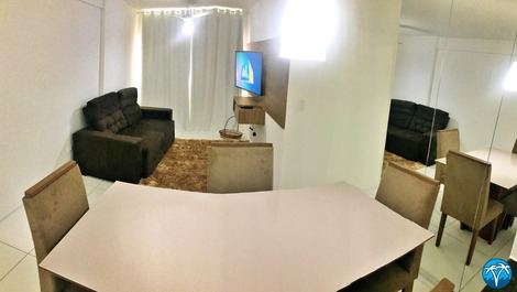 Sala de estar espaçosa com sofá retrátil e smart tv.