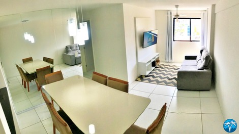 Sala de estar espaçosa com sofá retrátil e smart tv.