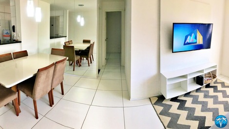 Sala de estar espaçosa com sofá retrátil e smart tv.