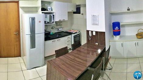 Copa e cozinha equipada com geladeira, fogão, micro ondas, talheres, copos e panelas. 