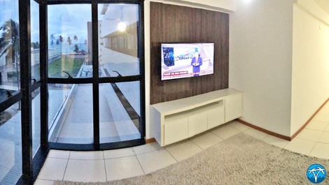 Sala de estar espaçosa com sofá retrátil e smart tv.