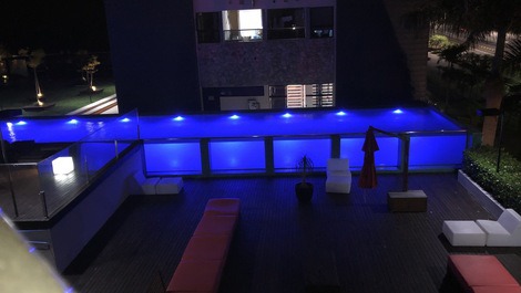 Visão noturna da piscina da sacada do loft.