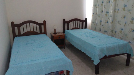 Quarto de solteiro, com duas camas e uma bicama.