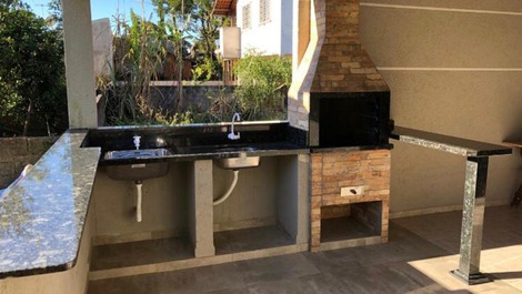 Churrasqueira com pia, tanque e bancada de granito. 