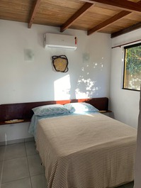 Quarto com cama box de casal e ar condicionado.