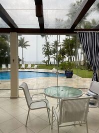 Uma das mesas da área  gourmet,  com vista para a piscina e praia