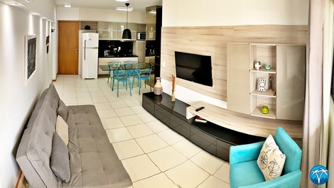 Sala de estar espaçosa com sofá retrátil e smart tv.