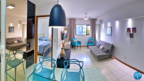 Sala de estar espaçosa com sofá retrátil e smart tv.