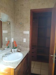 Banheiro e armário do closet da suíte 1