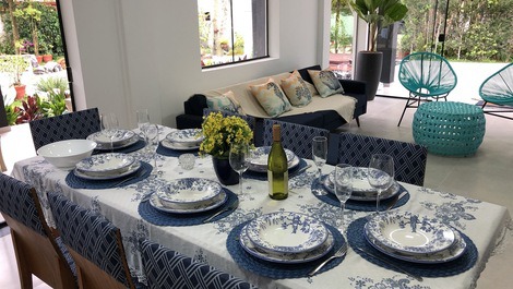 Sala de jantar integrada a sala de estar e living. louças, taças e talheres disponíveis