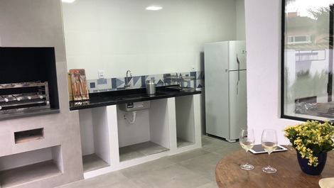 Churrasqueira gourmet com utensílios para o churrasco. porta à direita dá acesso a área de serviço