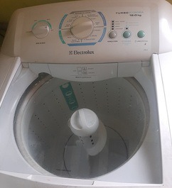 Lavanderia com maquina,varal e tanque.