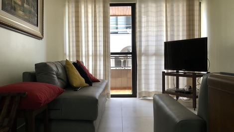 Sala com tv e varanda ao fundo