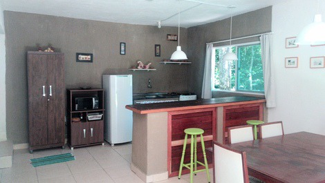 Casa - mar a ambos lados y rodeada de vegetación.