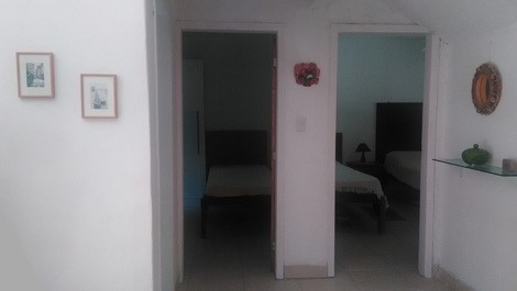 Casa - mar a ambos lados y rodeada de vegetación.