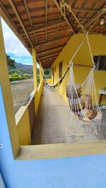 Varanda com rede e cadeira suspensa