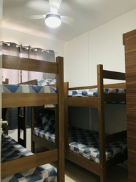 Quarto de solteiro com duas beliches, ventilador de teto, cortina blackout para os quartos 