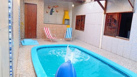 Área externa com piscina , churrasqueira, cascata de golfinho , cadeiras de praia.