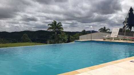 Granja en la naturaleza con piscina de borde infinito