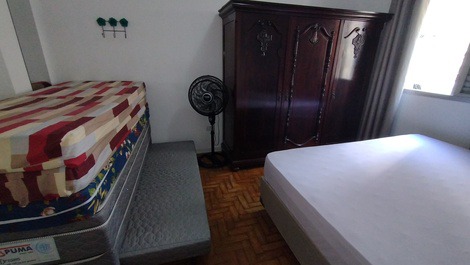 Quarto com cama de casal, bicama e colchões