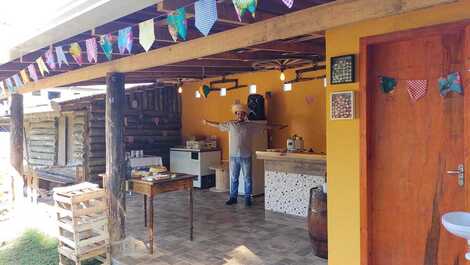 Espaço coberto com churrasqueira, geladeira e freezer.