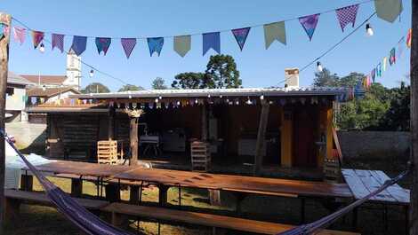 Espaço coberto com churrasqueira, geladeira e freezer.