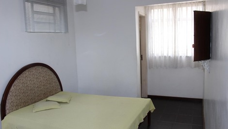 Quarto 1 - suite com ventilador de teto , armário e cortina . 