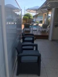 Área agrupada com churrasqueira e piscina para atendimento dos hóspedes .