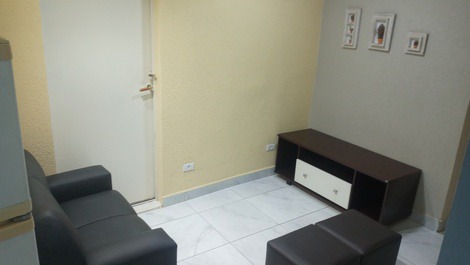 Sala de estar com rack, 2 puffs e sofá de 2 lugares