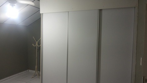 Quarto com amplo armário e cabideiro de chão 