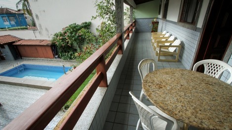 Varanda, onde se vê  um pouco das montanhas e o quintal. 